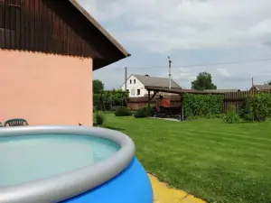 Pohled od bazénu k pergole s venkovním posezením